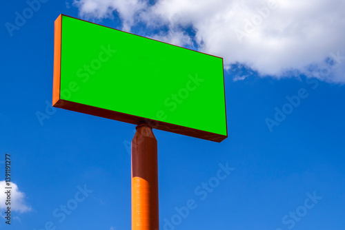Obraz na płótnie Mockup of the chromakey green billboard under a bright blue sky with white clouds. Outdoor advertising space ready for a message. Simple and clean composition in Brazil w salonie