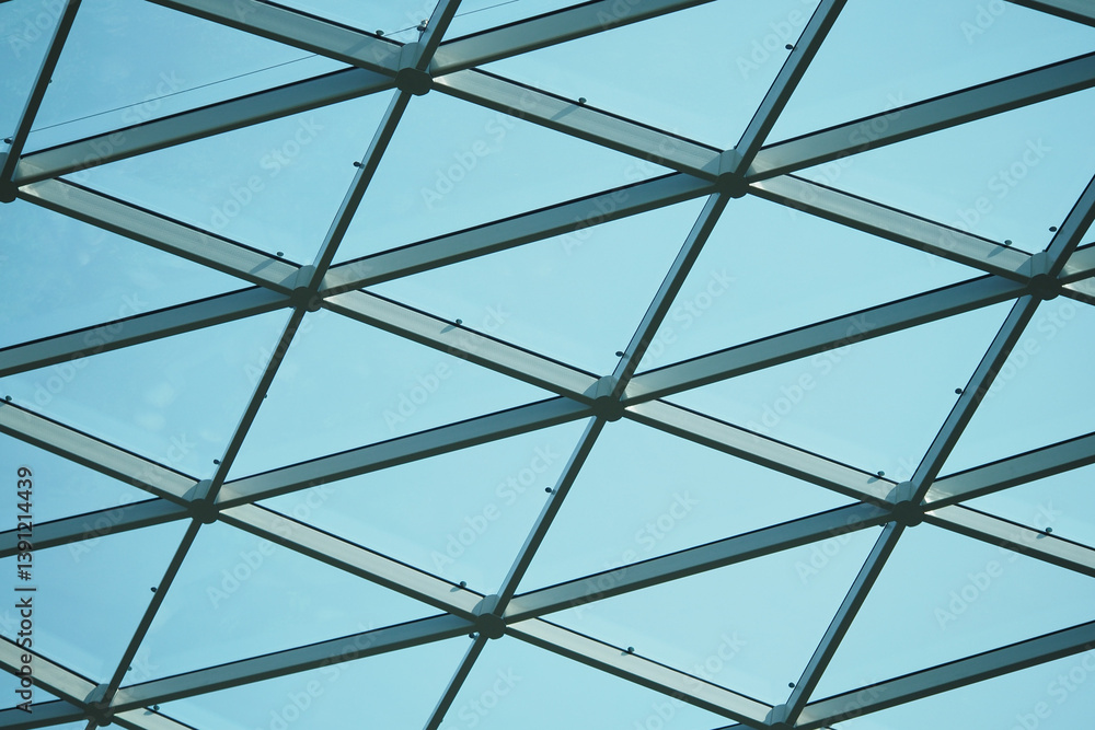 Fototapeta premium Modern glass structure creates a striking pattern against the sky