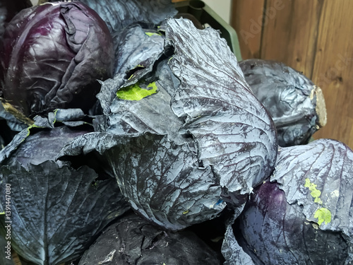 Red cabbage in a wooden box close-up. Vegetable trade at the market. Cabbage with red and purple leaves. 