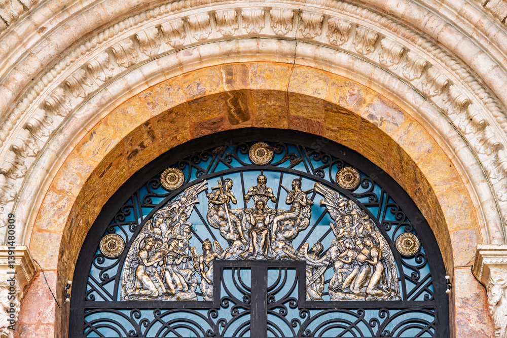 Obraz premium Ornamental bronze relief with religious motifs on the main entrance gate of the Cathedral of the Immaculate Conception in Cuenca, Ecuador, showcasing detailed colonial craftsmanship