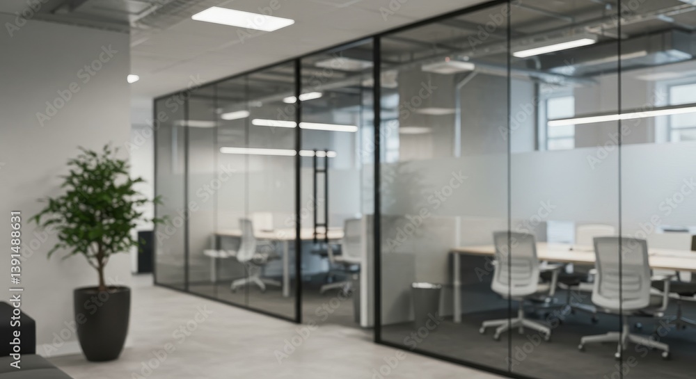 Fototapeta premium Blurred view of modern office space with glass walls and a potted plant near the entrance