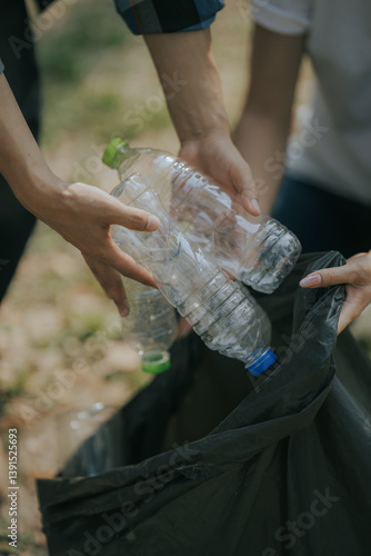 Volunteers collect plastic bottles, put trash in black trash bags to clean the park, avoid pollution, be environmentally friendly and ecologically friendly.