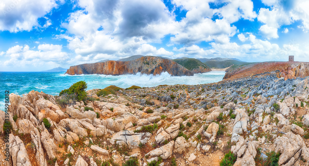 Attractive view of cliffs in valley Cala Domestica with old tower and storm on the sea