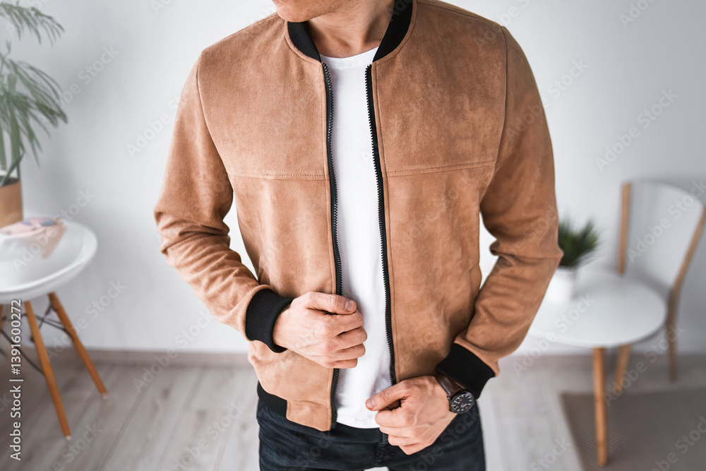 Man standing in stylish interior wearing brown suede jacket and casual outfit