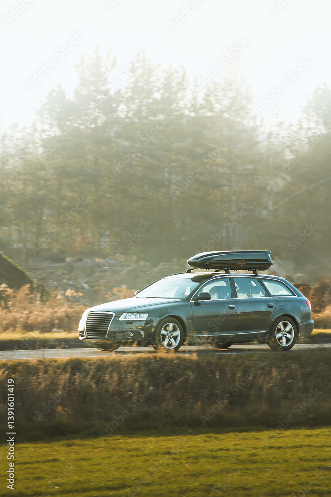 Travel SUV with roof cargo box on scenic drive