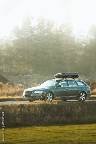 Obraz na płótnie Travel SUV with roof cargo box on scenic drive w salonie