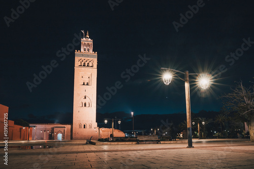 Obraz na płótnie The Koutoubia Mosque and its minaret standing tall in Marrakech's Djemaa el Fna square, illuminated at night w salonie