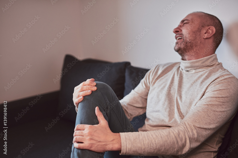 Man with painful knee and leg injury at home.