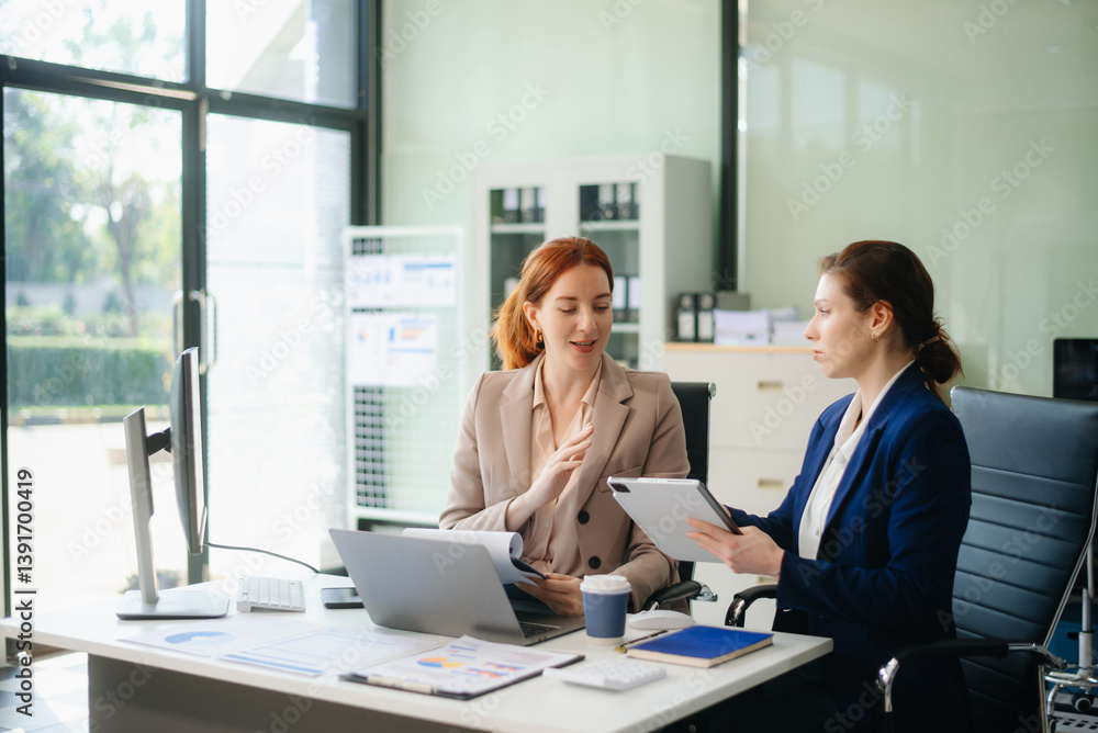 Fototapeta premium Businesswoman leading team meeting and using tablet and laptop computer with financial