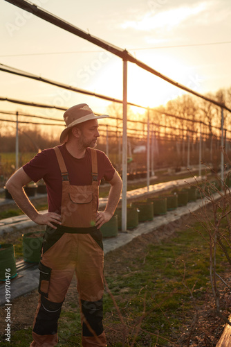 Obraz na płótnie Male gardener with hat working in a blueberries organic farm. w salonie