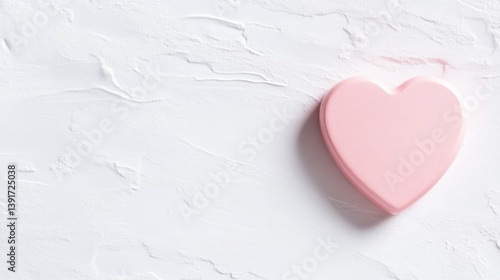A soft pink heart on a textured white surface