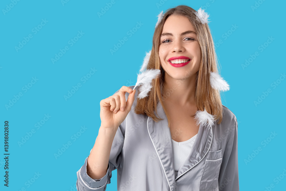 Portrait of pretty young woman in pajamas with feathers on blue background Portrait of pretty young woman in pajamas with feathers on blue background