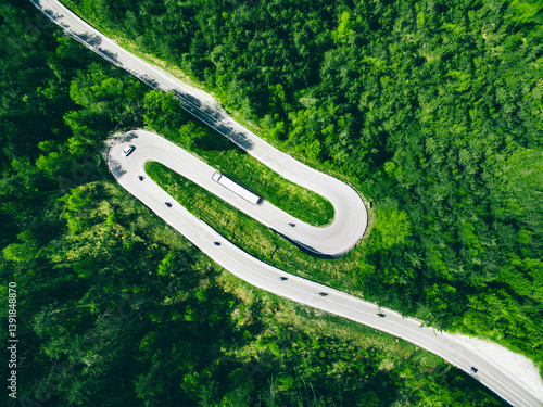 Obraz na płótnie Aerial view of winding road in green forest with car, semi-trailer truck and motorcycles in Italy w salonie