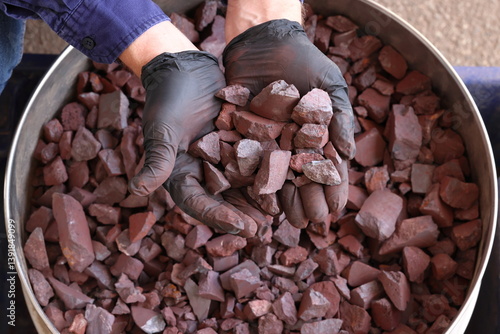 Sample of high-grade hematite iron ore from the Pilbara region, Western Australia, held in hand. World's largest source of iron ore