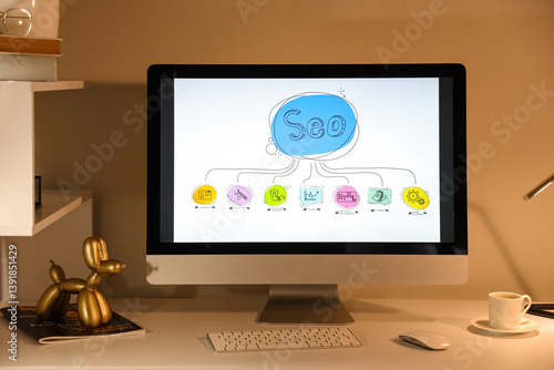Foto Computer screen with abbreviation SEO in cozy dark office