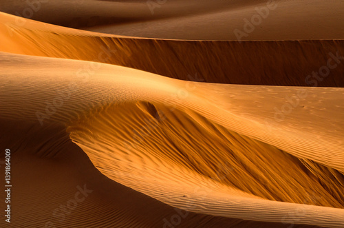 Abstract sand dunes in the desert landscape of Oman near A'Sharqiyah Sands under the warm sun
