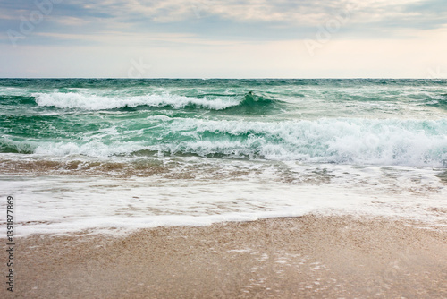 seascape in morning light. bad vacation season background. tide and foam on the shoreline. stormy weather with cloudy sky in summer. sea wave crashing on the shore. wind freshness