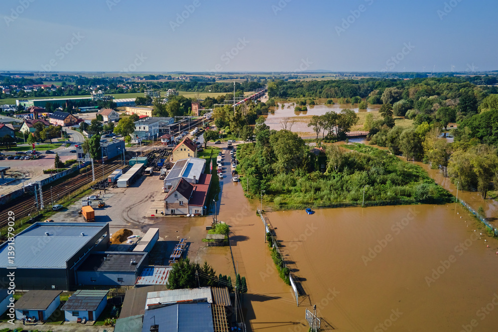 Aerial view of flooded streets, railway tracks and buildings in a suburban area. Industrial zone with floodwater after heavy rain. Concept of natural disaster, climate impact and emergency