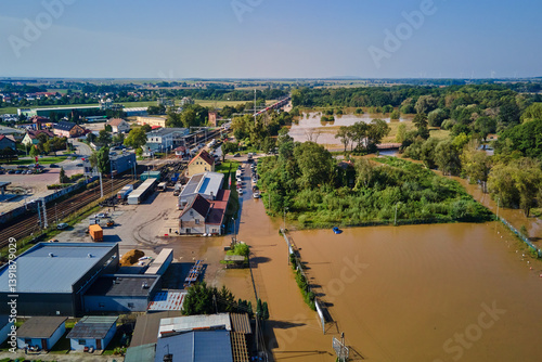 Obraz na płótnie Aerial view of flooded streets, railway tracks and buildings in a suburban area. Industrial zone with floodwater after heavy rain. Concept of natural disaster, climate impact and emergency w salonie