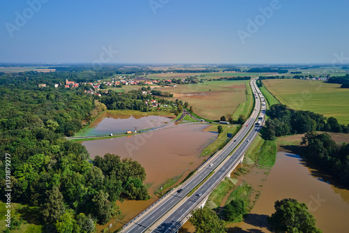 Obraz na płótnie Aerial view of flooded fields and submerged rural road near busy highway. Concept of climate impact, transportation disruption and natural disaster w salonie