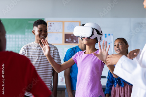 Obraz na płótnie Using VR headset, students in school classroom exploring virtual reality together w salonie