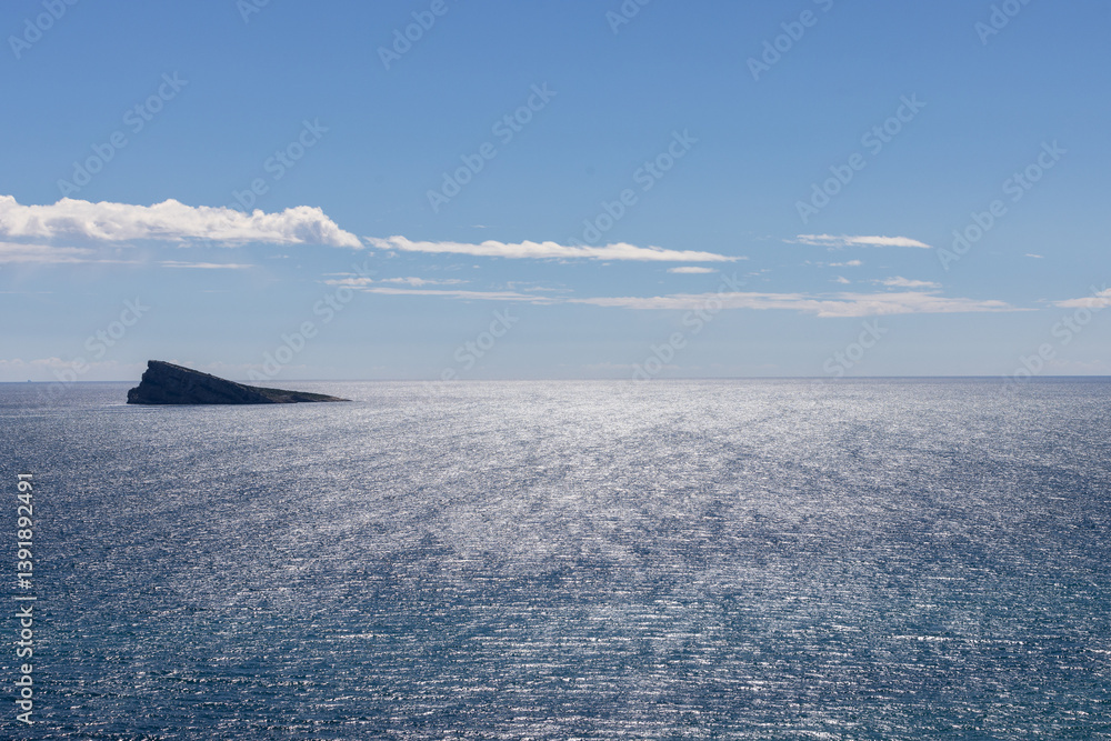 Photo of the town of Benidorm in Spain showing the rock in the middle of the ocean known as Isla de Benidorm or Mirador de l'Illa de Benidorm