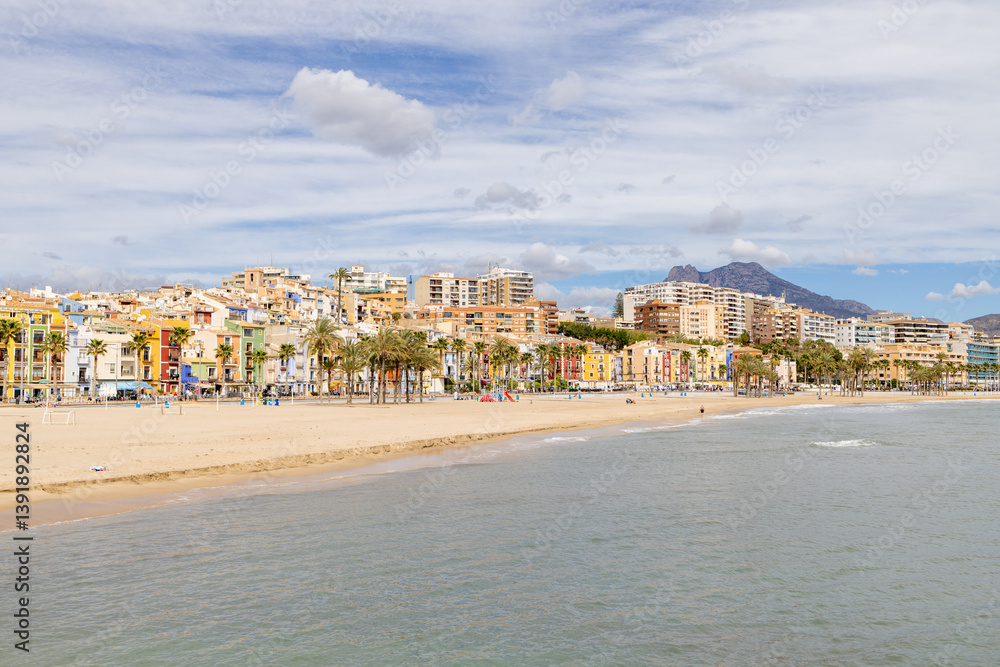 Photo of the beautiful town of Villajoyosa in Spain showing the beach front on a sunny day with hotels and guest houses on the beach front showing the sandy beach and ocean front Photo of the beautiful town of Villajoyosa in Spain showing the beach front on a sunny day with hotels and guest houses on the beach front showing the sandy beach and ocean front