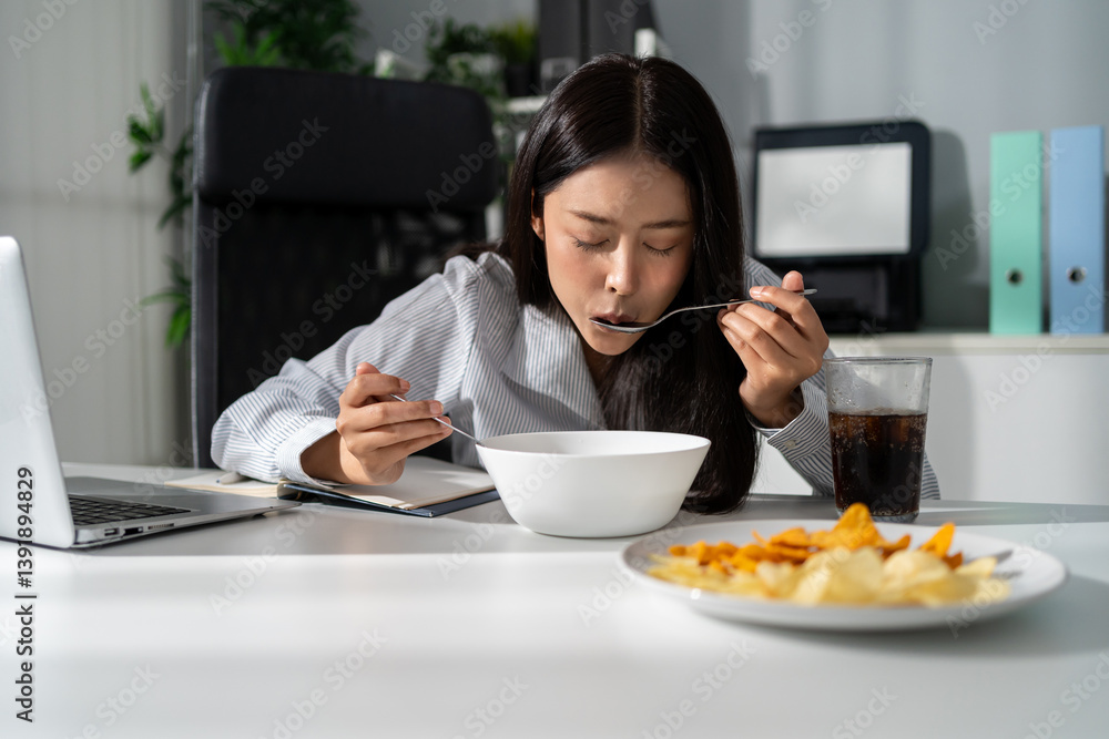 Asian young businesswoman eating noodles while working in the office. Asian young businesswoman eating noodles while working in the office.