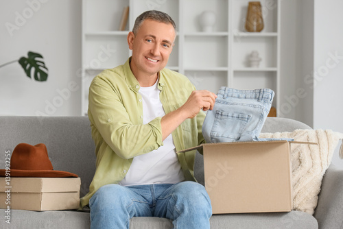 Mature man unpacking box wi...