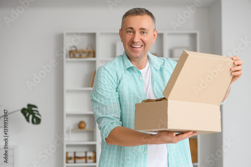Mature man unpacking box wi...