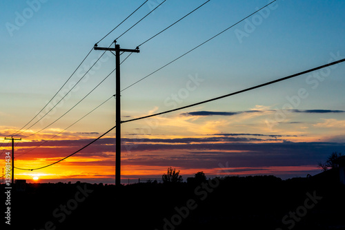 Power transmission line poles against the sky at sunset