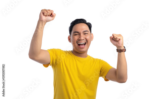 Excited handsome Asian man doing winner gesture with arms raised, shouting, celebrating success isolated on transparent background