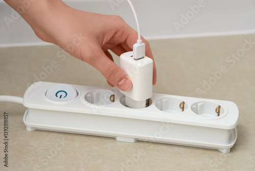 Hand plugging white USB cha...
