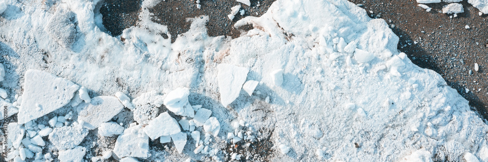Top view of the ice floes on the shore. White ice on the sea beach. Wide panoramic background.