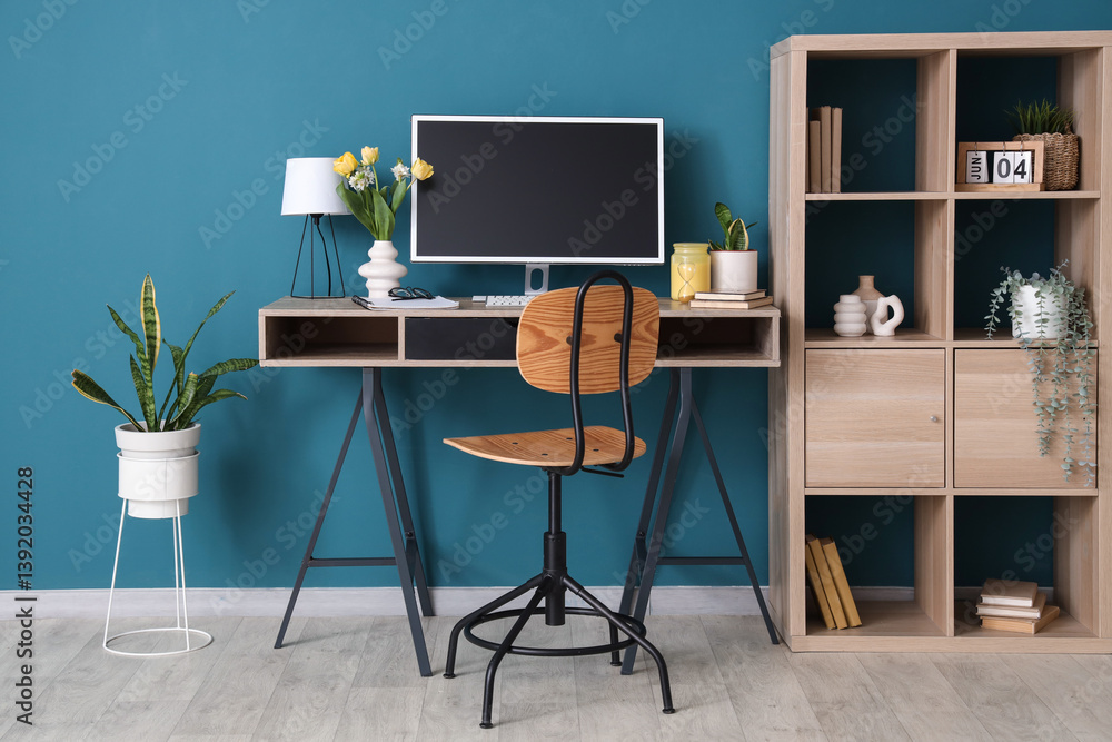 Fototapeta premium Interior of office with workplace, flowers and shelf unit