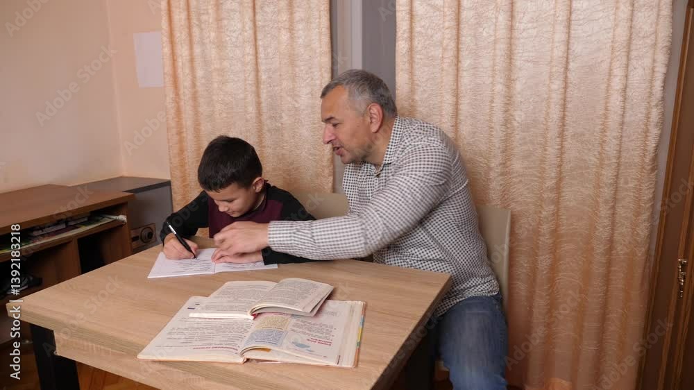 Father helping his son with homework. Home education concept. Father helping his son with homework. Home education concept.