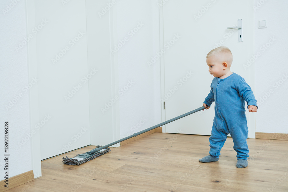 Little boy helper cleaning at home. Blond toddler boy washes the floor with a mop, helping his mother clean at home, free space. Child learns to clean the house.
