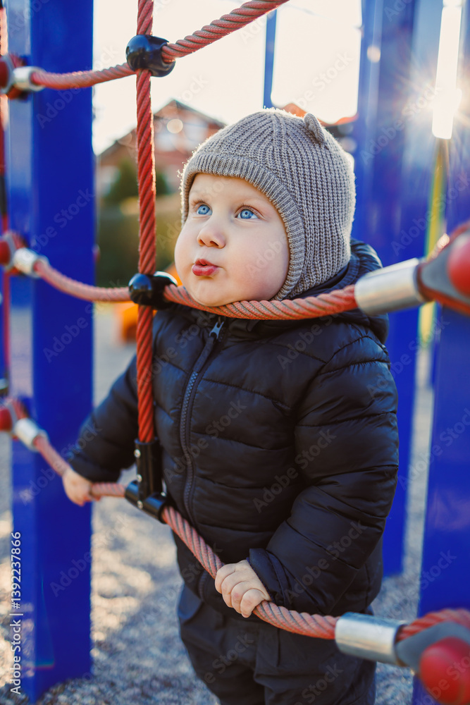 Happy toddler boy on a walk on the playground. Child development, healthy lifestyle of the child. Boy outdoors on an autumn walk.