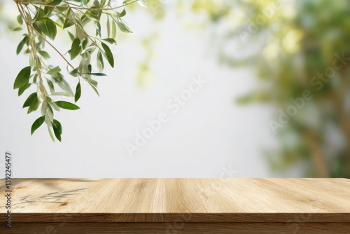 Natural wooden table with hanging green leaves and soft blurred garden background, perfect minimal mockup for organic product display, branding, packaging, or summer presentation