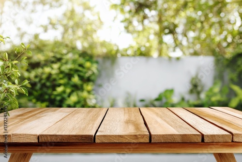 Obraz na płótnie Wooden tabletop with blurred green garden background, natural outdoor scene perfect for product display mockups, food presentation templates, or summer lifestyle promotional design w salonie