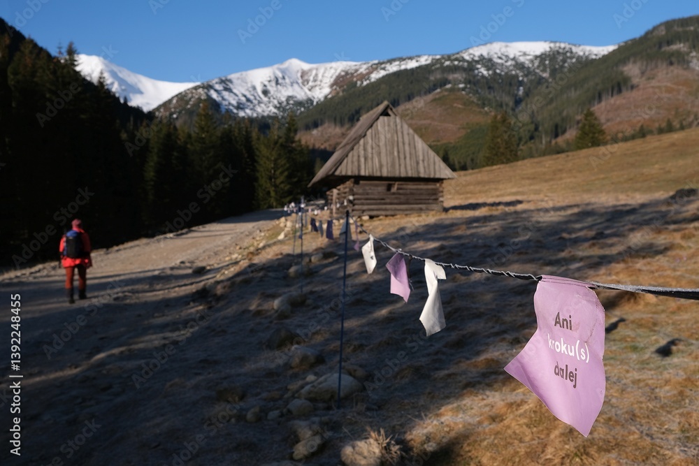 Shepherds' hut in Chochołowska Valley and string fence with note on card saying: Not step further. Tatra Mountains, Zakopane, Poland