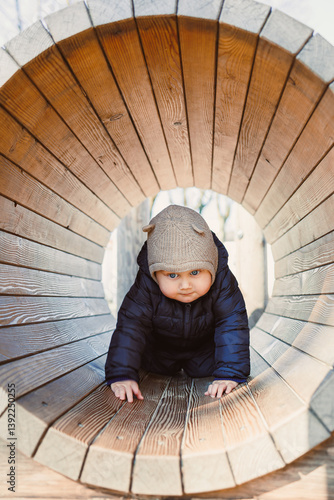 Child walking outdoors. Happy toddler boy on a walk on the playground. Child development, healthy lifestyle of the child. Boy outdoors on an autumn walk. Cheerful boy in the city park.