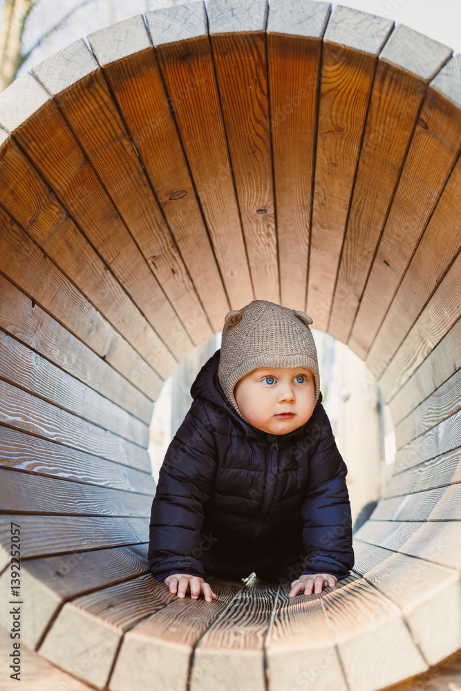 Child walking outdoors. Happy toddler boy on a walk on the playground. Child development, healthy lifestyle of the child. Boy outdoors on an autumn walk. Cheerful boy in the city park.