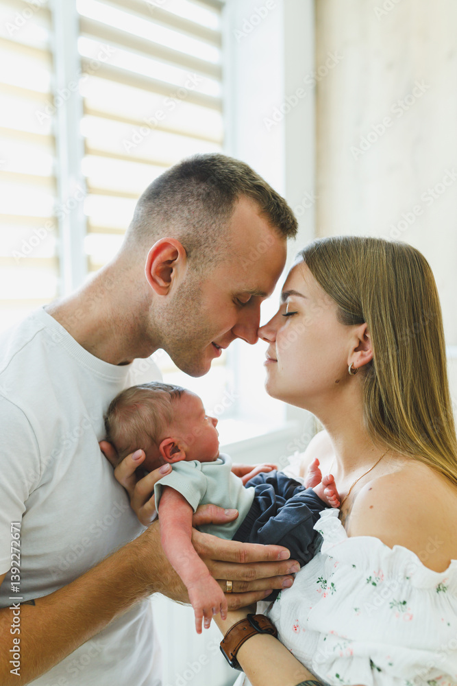 This portrait captures a heartfelt moment of parents kissing their newborn, creating lasting memories filled with love and joy as they celebrate the profound experience of parenthood together