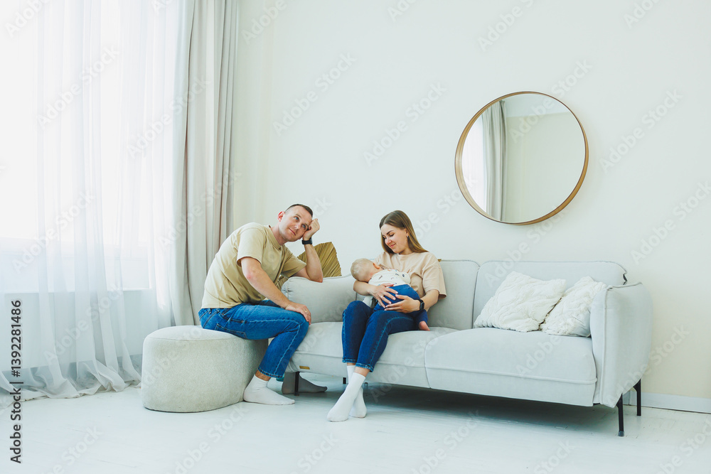 A warm and candid family moment captures parents nurturing their infant in a bright, modern living room filled with light, showcasing the deep connections and joyful bonds of parenthood