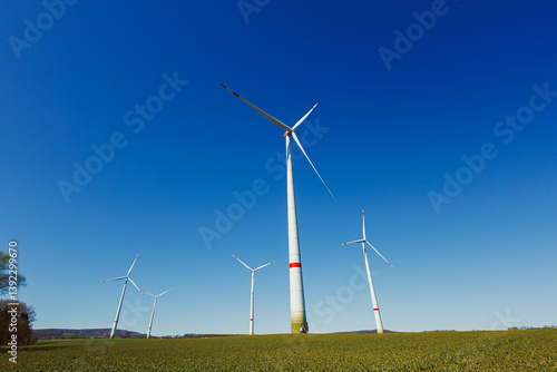 Obraz na płótnie Wind turbines generating energy against a clear blue sky. Wind turbines generating clean renewable energy for sustainable development w salonie