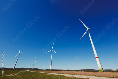 Obraz na płótnie Wind turbines generating energy against a clear blue sky. Wind turbines generating clean renewable energy for sustainable development w salonie