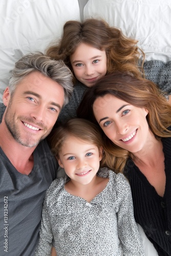 Portrait of a happy black family smiling, captured from above while lying in bed