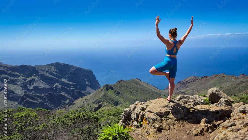 Young woman practicing yoga in tenerife, spain, enjoying breathtaking view of mountains and ocean Young woman practicing yoga in tenerife, spain, enjoying breathtaking view of mountains and ocean