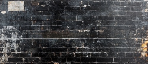 Aged black brick wall with peeling paint